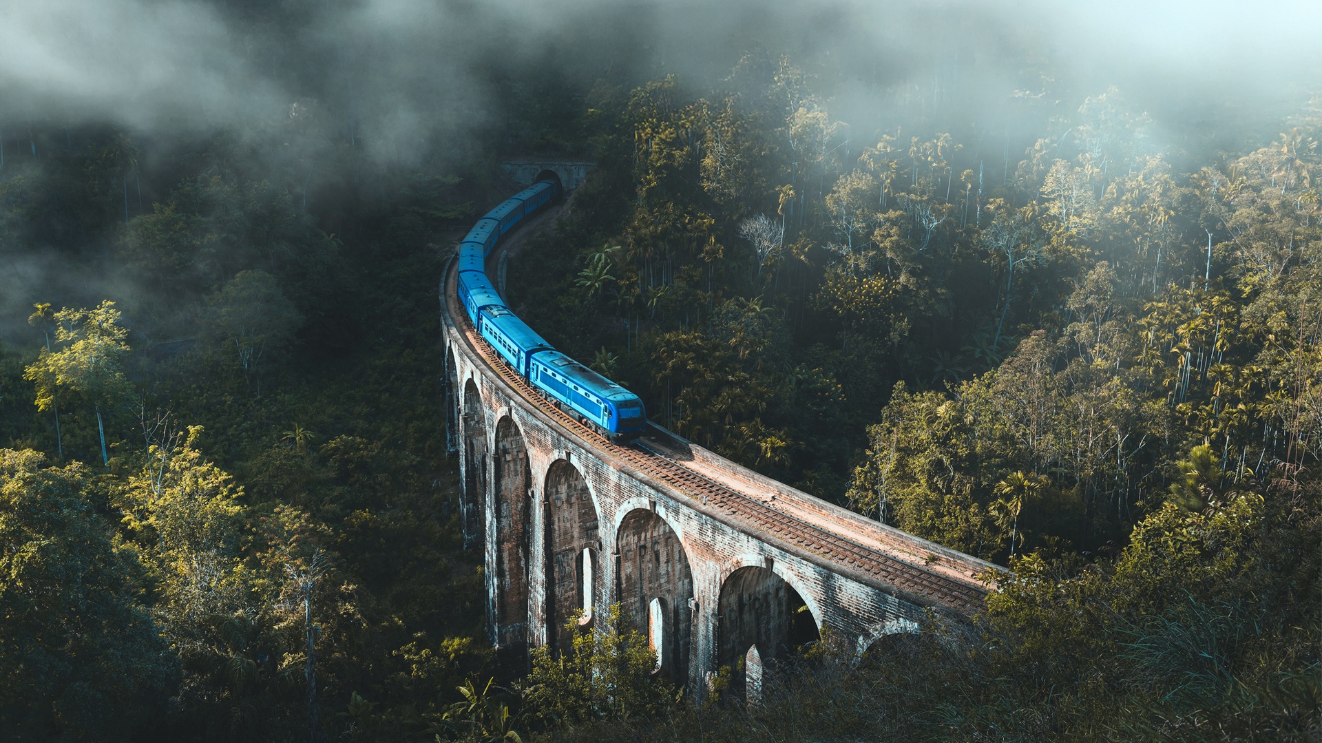 Scenic blue train crossing the Nine Arches Bridge in Sri Lanka